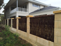 Brushwood panels and masonry combined as a boundary fence